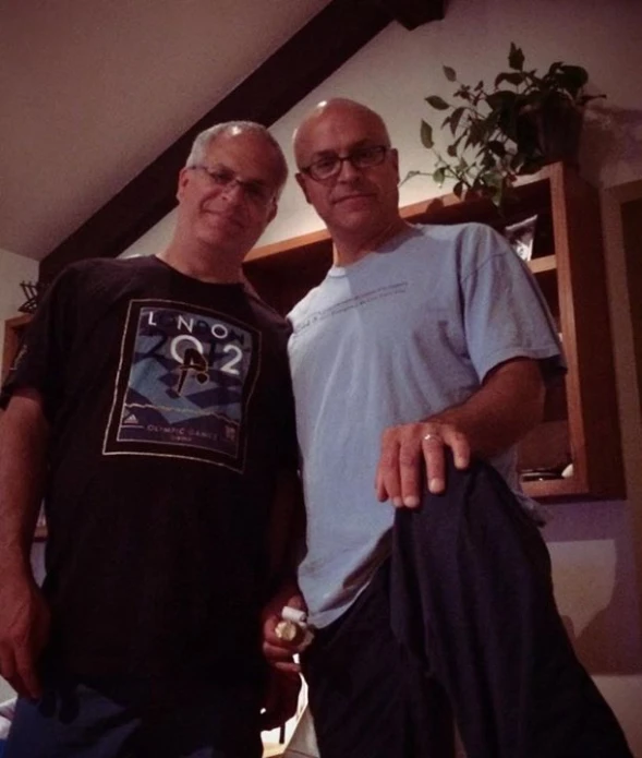 the two men are posing for a picture in the room