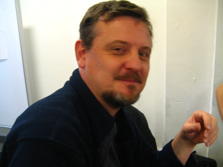 man holding food with finger in front of his face