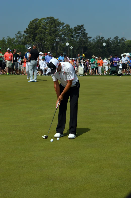 a golf player about to put his ball into the green