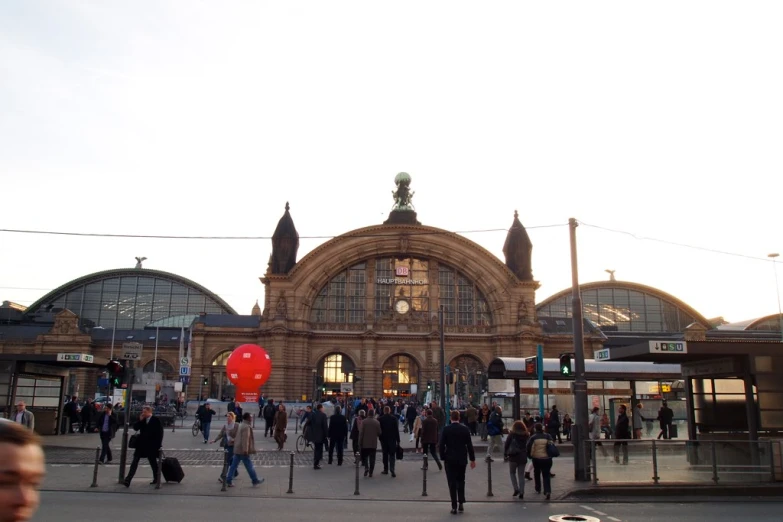 people walking outside a train station at night