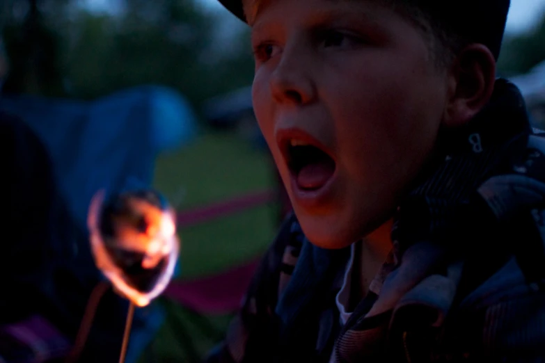 a boy holding a lit sparkler in his hand