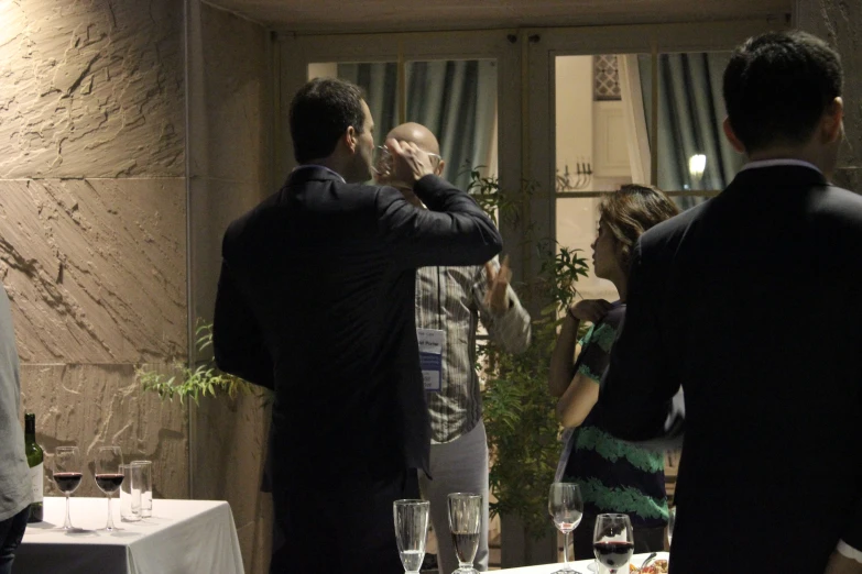 a group of people are standing at a table in a restaurant