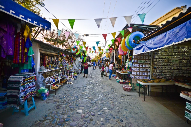 a large collection of colorfully strung streamers hang over a shopping street