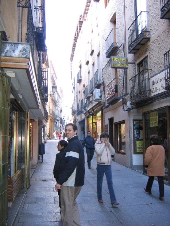 a group of people are standing on the side walk in an old town