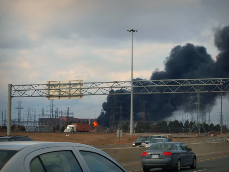 black smoke billowing out from a large cloud of dark smoke