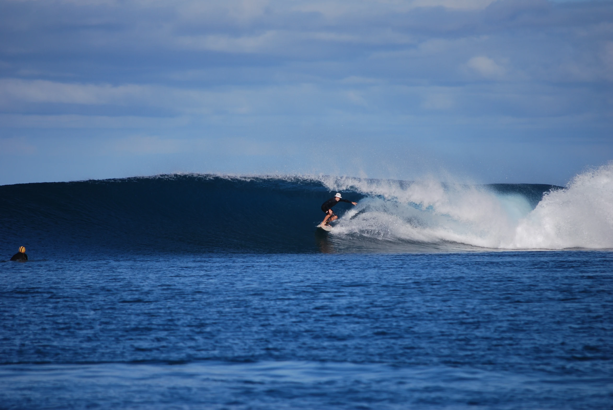 man riding large wave on top of surf board