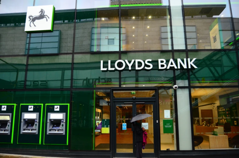 a lady that is standing in front of lloyd's bank