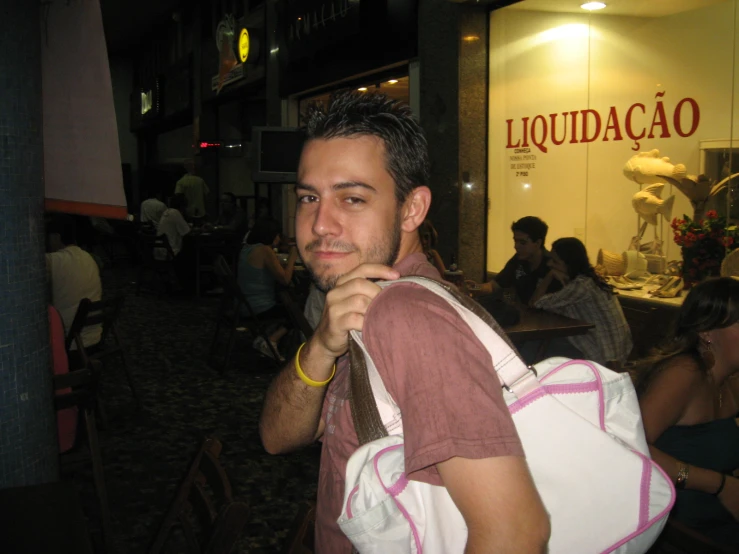 a man in a red shirt carrying a white bag