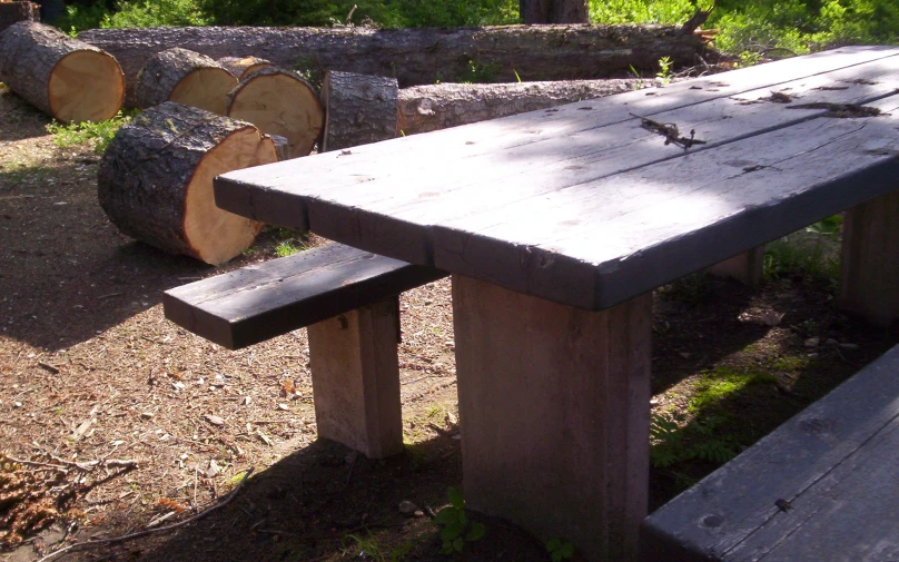 there is a wooden picnic table with two benches