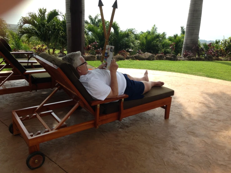 man lying on top of an outdoor chaise lounge