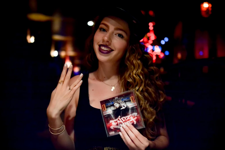 a young lady with a weird look holding up a cd