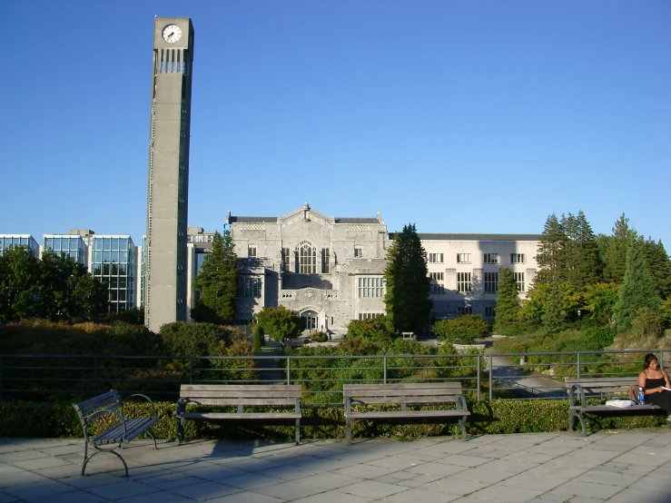 benches and a tower on a building with trees