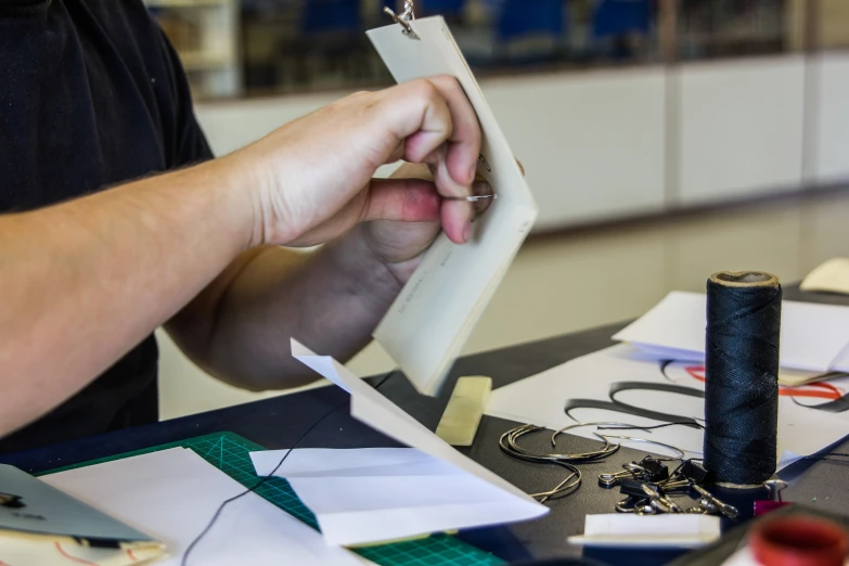 a man at a table working on some craft paper