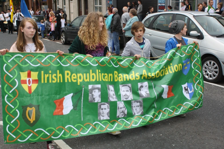 a group of people holding a large banner with a picture of irish politicians