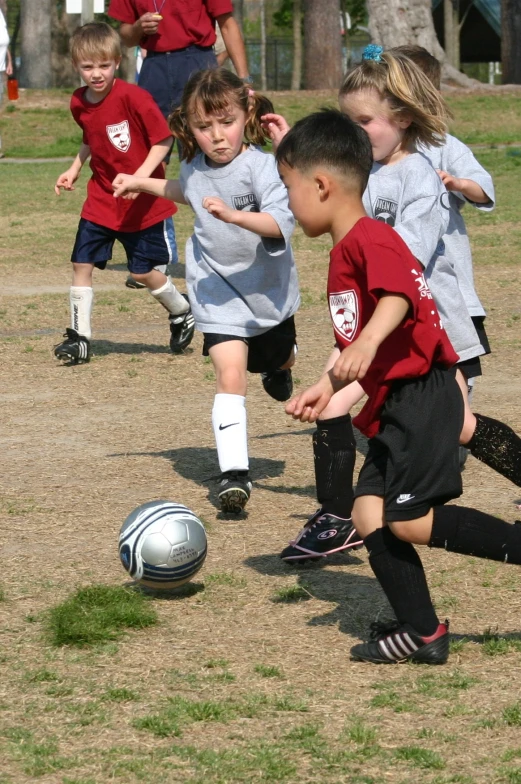 some children playing soccer while one  kicks the ball