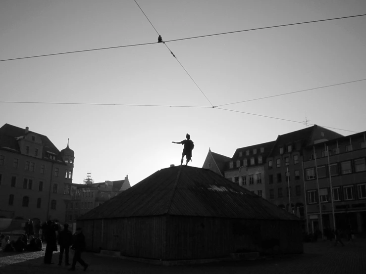 a man riding on the back of a kite near buildings