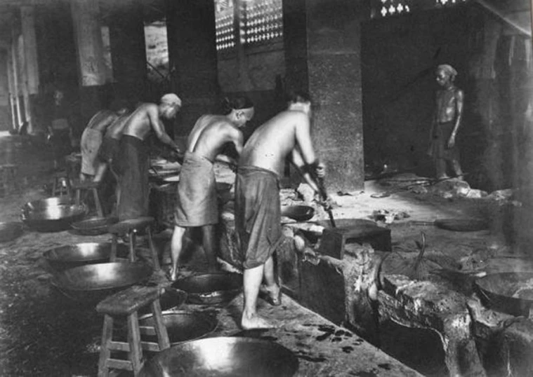 an old picture of some people cooking in a room