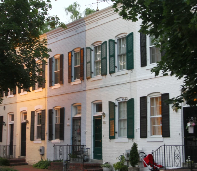 two story white house with green shutters at dusk