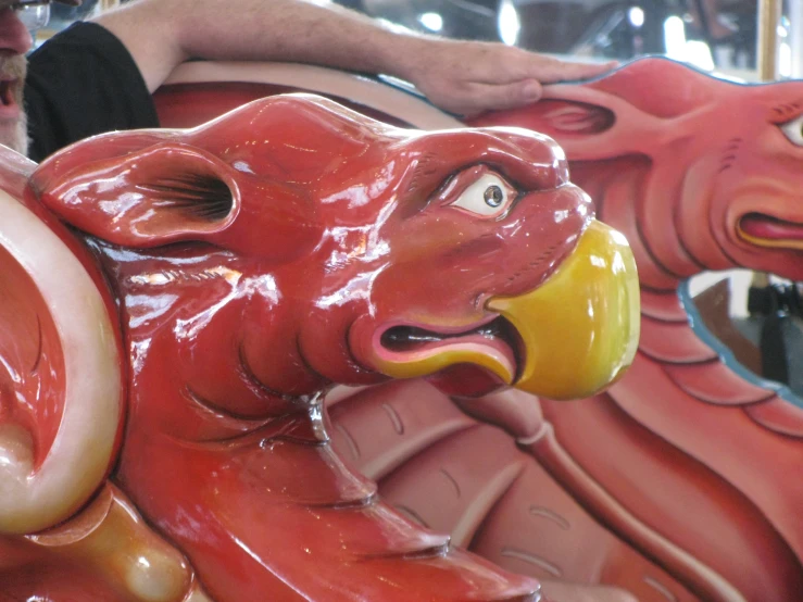 a carnival has red lion heads and people watching