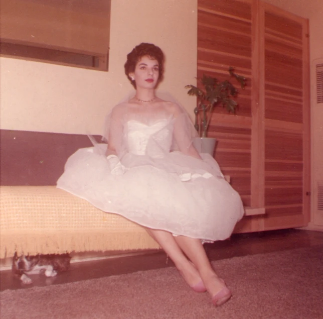 the woman is dressed up in white and posing for a picture