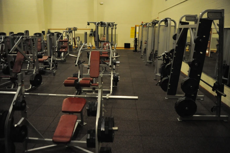 many weight machines in the middle of a gym floor