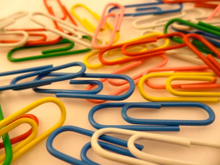 various colored paper clips scattered on top of each other