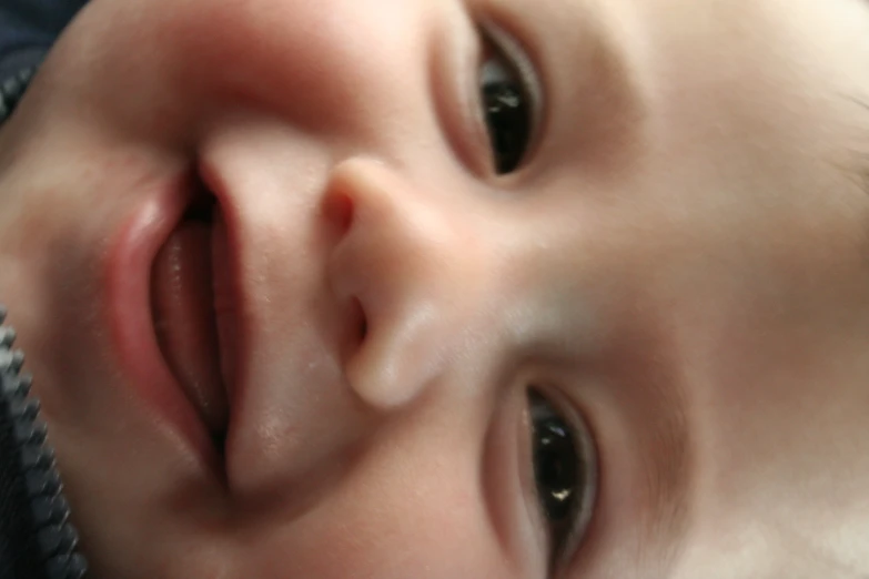 the smiling baby has black eyes and no nose
