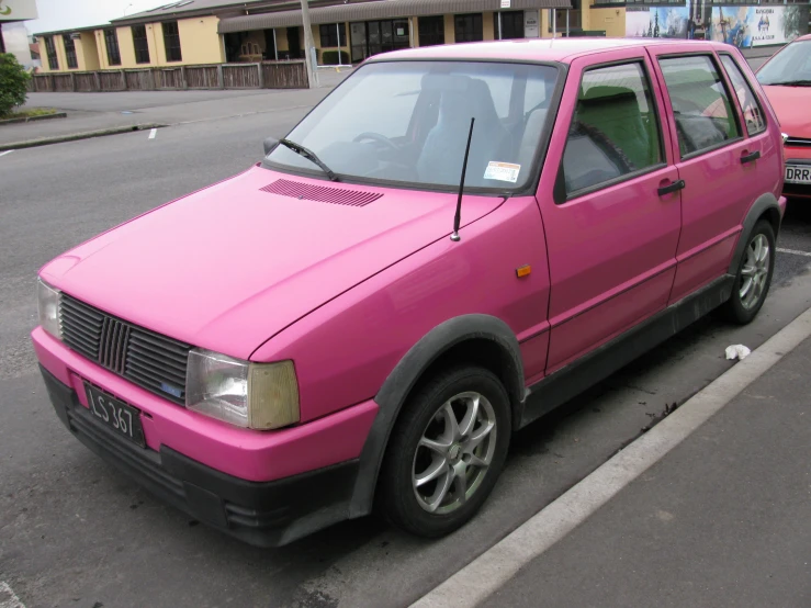 pink car parked on the side of the street