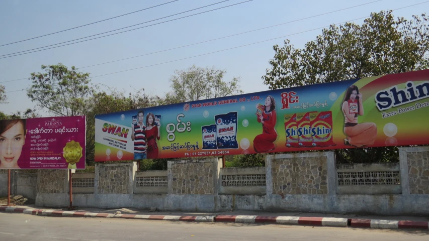 billboards on both sides of a road near a traffic light