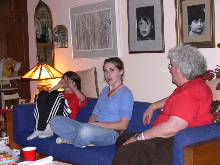 people in the living room on a couch watching tv