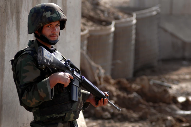 a man in camouflage gear holding a machine gun