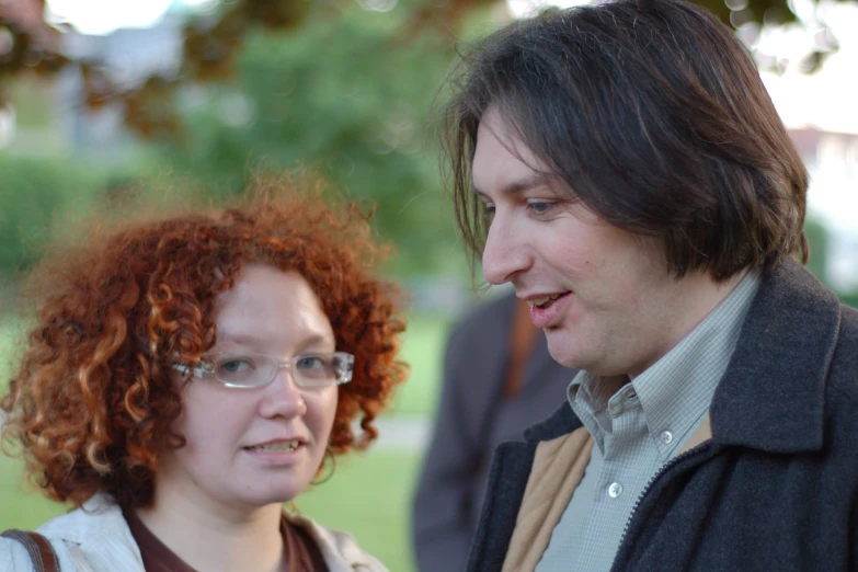 an old woman and a young man standing together