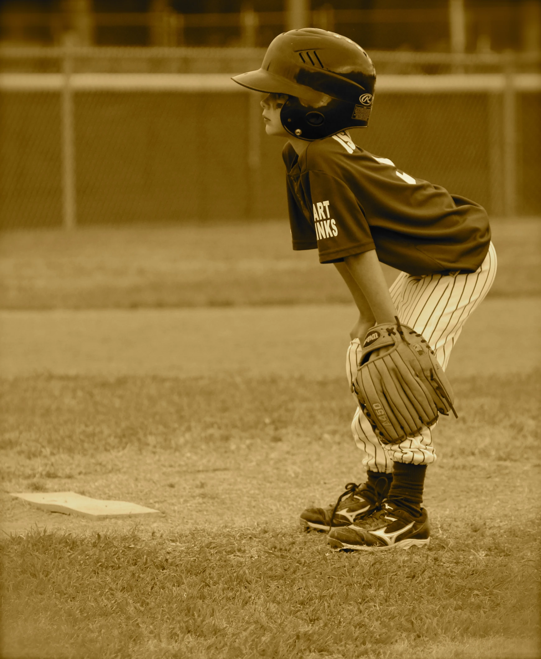 a boy in baseball uniform holding his leg