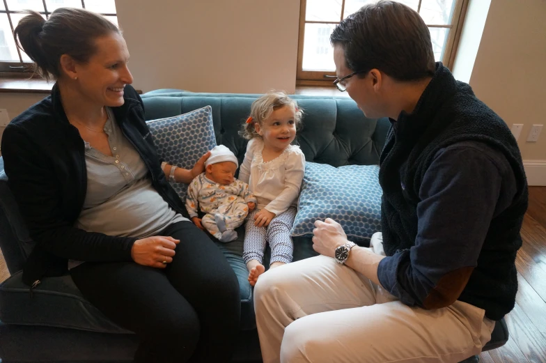 a young woman and a small child sit on the couch