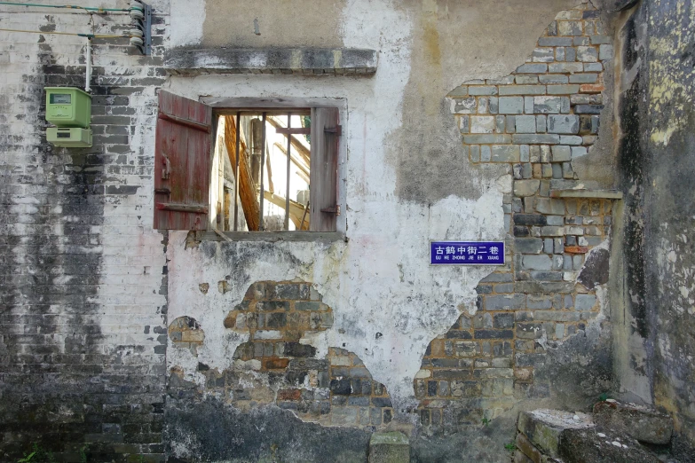 a white building with red shutters and blue sign