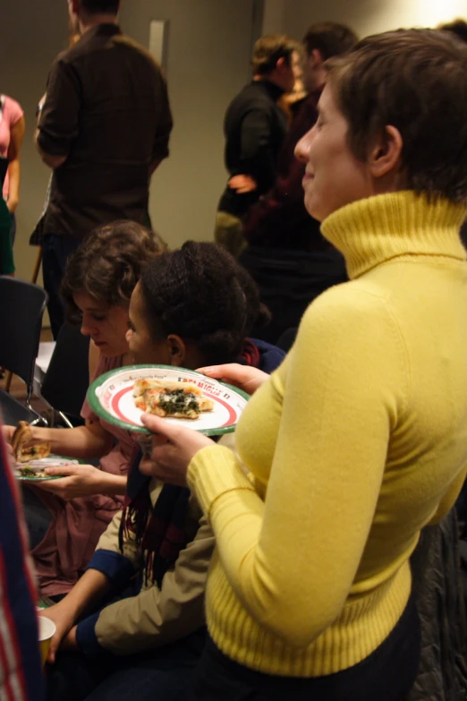 a group of women at a conference holding plates