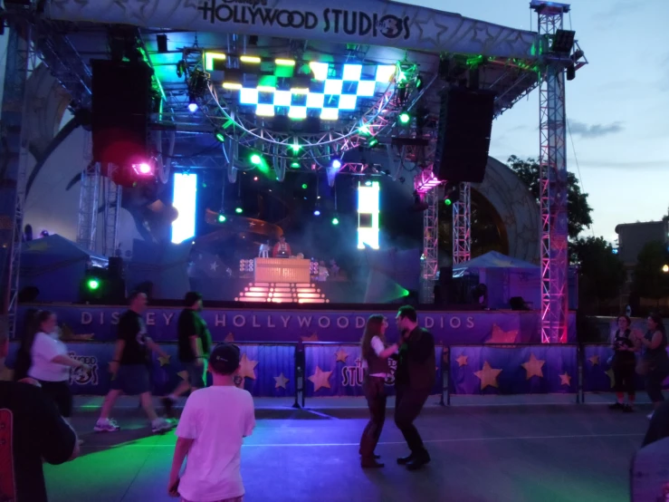 several people in front of a stage lit up with lights