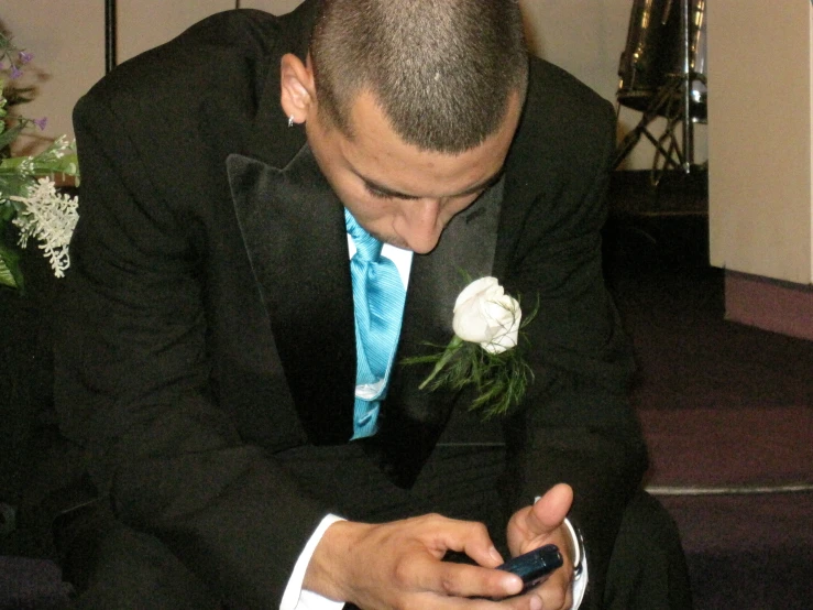 a man in a suit is looking at his cellphone
