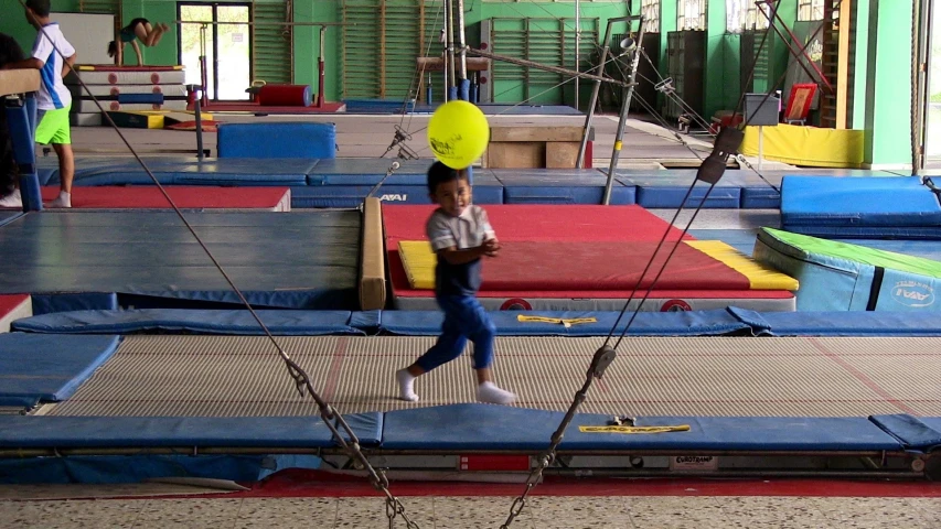 a child is on the trampoline with a frisbee