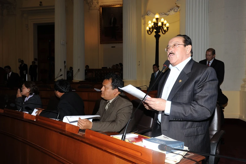 two men speaking at the front of a room