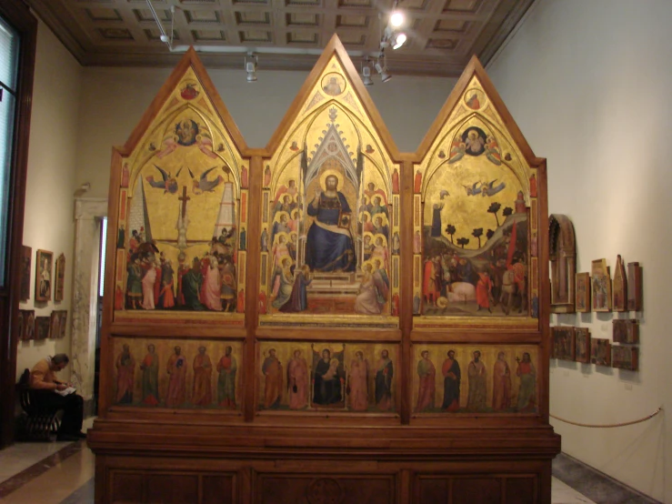 paintings and a bench in a museum with an arched ceiling