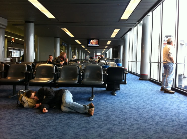 people are sleeping in an airport waiting for the next flight