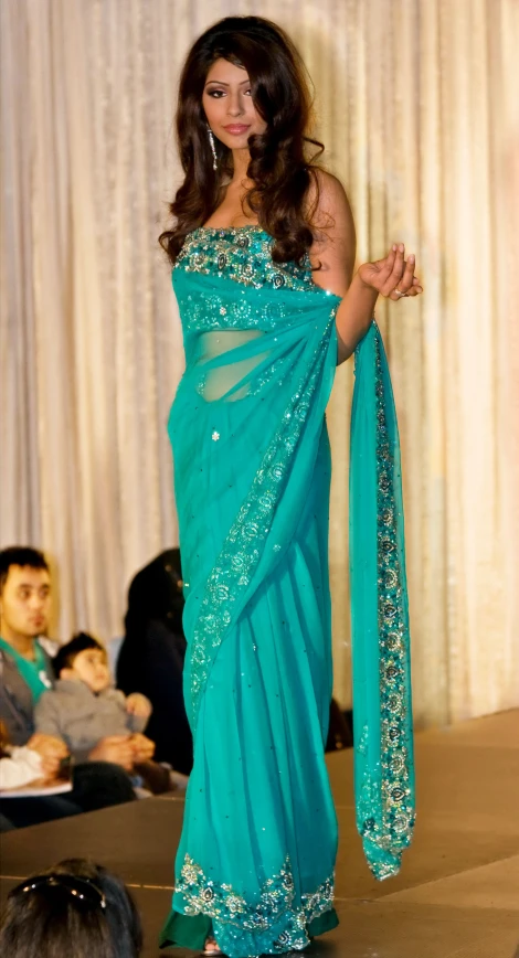 a woman with a blue sari is on the runway