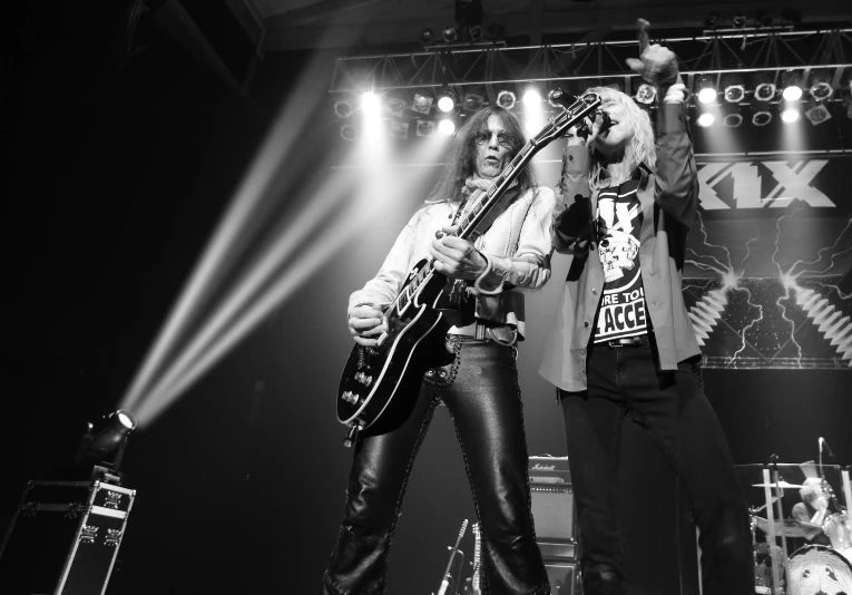 a couple of men are playing guitars on stage