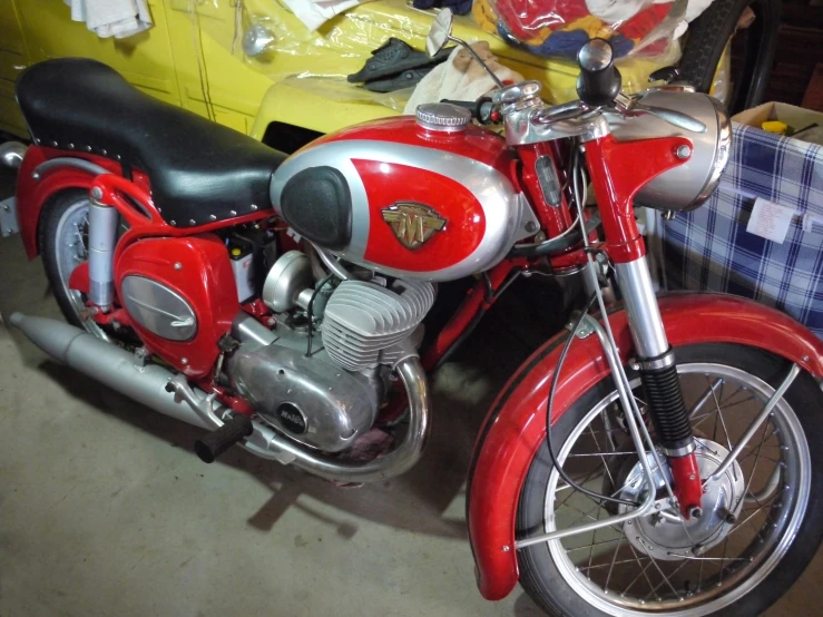 a red motor cycle parked on a garage floor