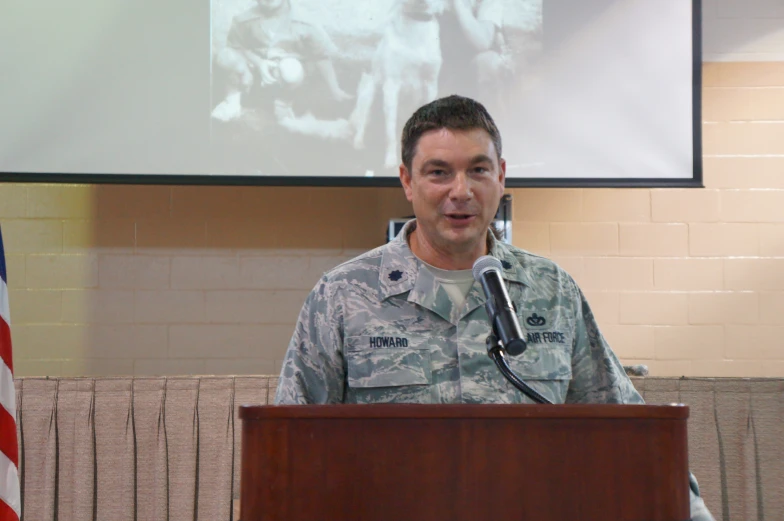 a man wearing a uniform speaks into a microphone