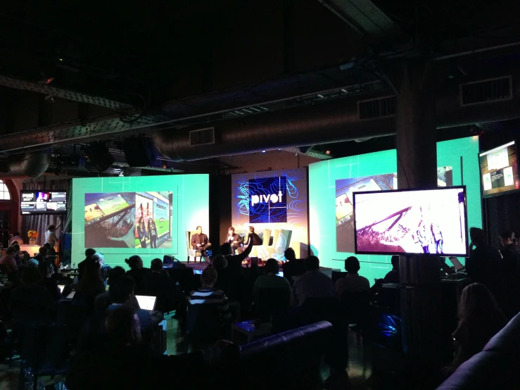 a large room filled with many people watching various displays