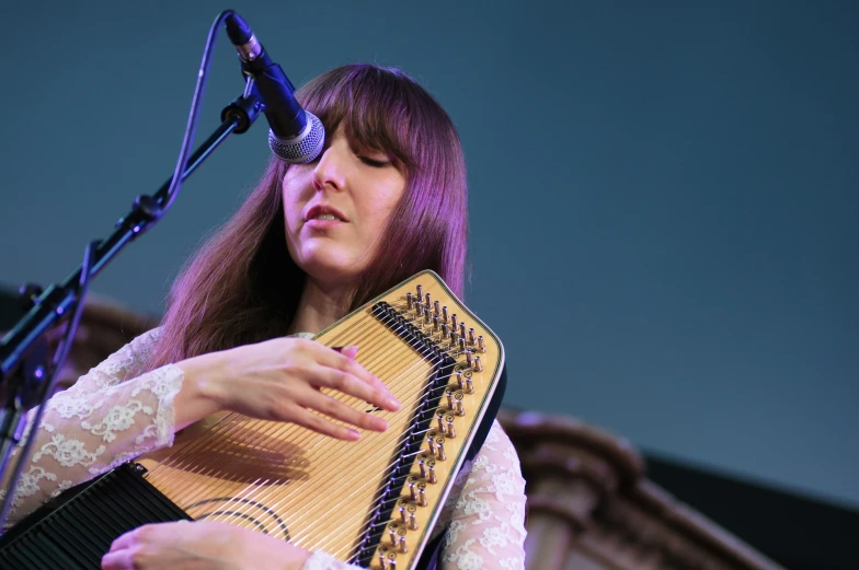 woman playing an instrument in front of microphone