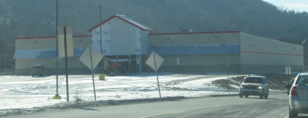 a store on the side of the road with snow in front of it