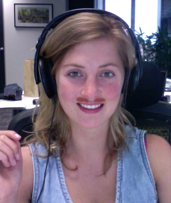 a woman with a moustache is wearing headphones